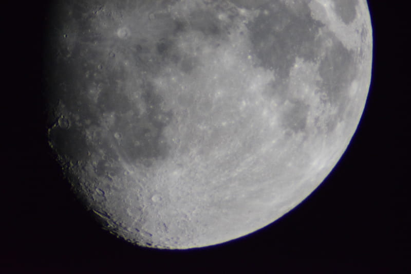 A photograph of the Moon, taken through a telescope.